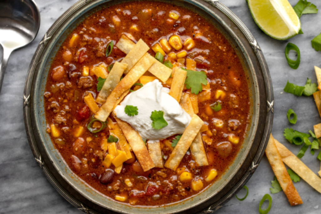 A steaming bowl of taco soup with ranch dressing