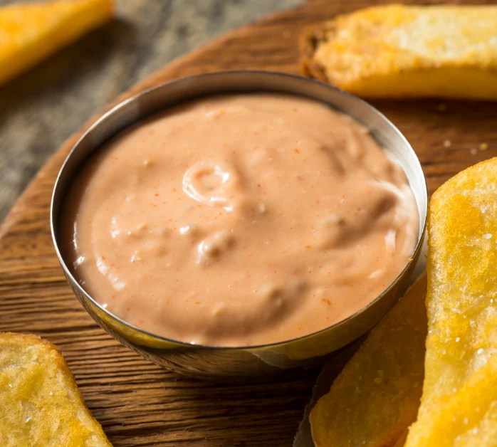 Delicious homemade Freddy's Fry Sauce in a bowl, surrounded by crispy golden fries, ready to be dipped and enjoyed.